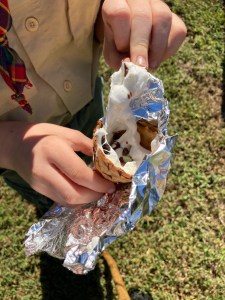Boy Scout holds a s’more made inside an ice cream cone.