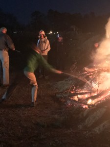 A teenage roasts a marshmallow in a bonfire.